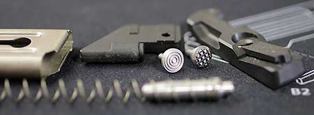 Ruger Mark magazine, disassembled. OEM and Volquartsen buttons shown