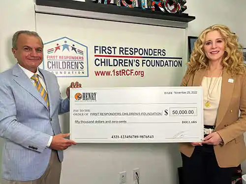Henry Repeating Arms CEO & Founder Anthony Imperato (L) presenting a $50,000 donation to FirstResponders Children‘s Foundation President & CEO Jillian Crane (R) at the organization‘s headquarters in
New York City.