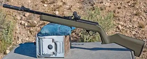 OD Green TandemKross TKX22 Light Rifle resting on a support at an outdoor shooting range.
