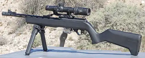 Black TandemKross TKX22 Light Rifle with a scope and bipod set up on a shooting bench.