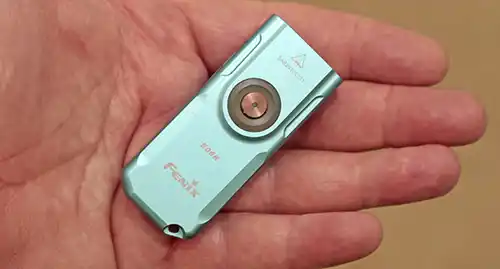Fenix E06R flat EDC flashlight shown in hand for size comparison