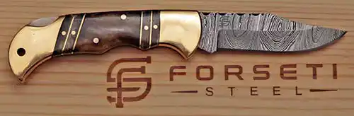 Damascus blade and stained bone brass handle detail on the Forseti Steel Hemingway