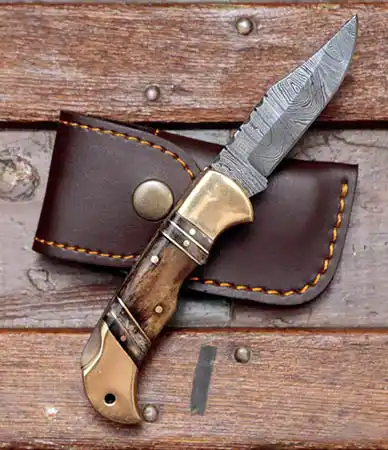 Forseti Steel Hemingway Damascus folding knife open on its leather sheath
